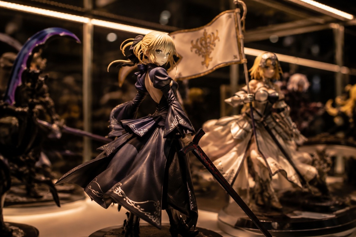 High-quality painted collectible figures displayed in illuminated glass cabinet in a Japanese specialty store